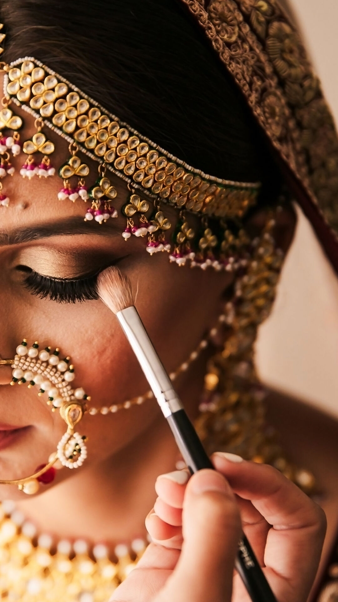 a bride getting her eye makeup done by her makeup artist
